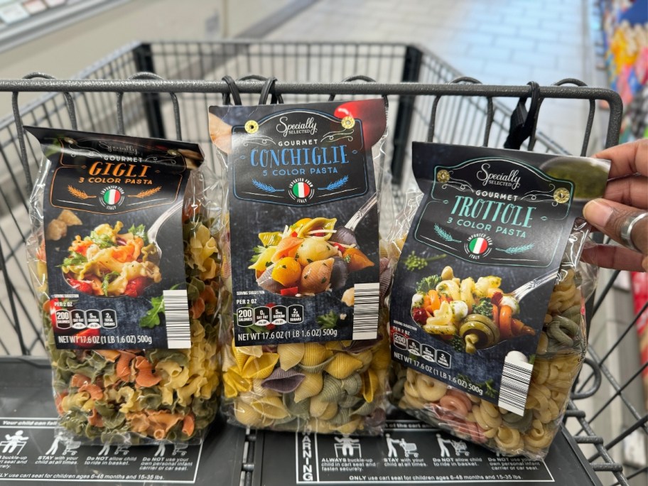 3 bags of pasta in the front of an Aldi shopping cart