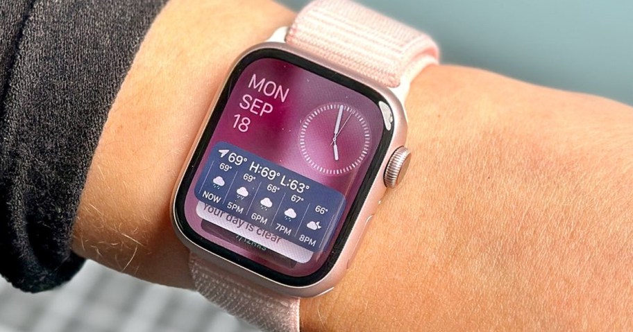 wrist with pink apple watch on it
