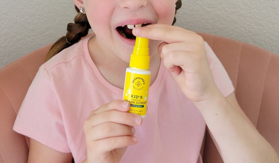 girl spraying throat spray in mouth