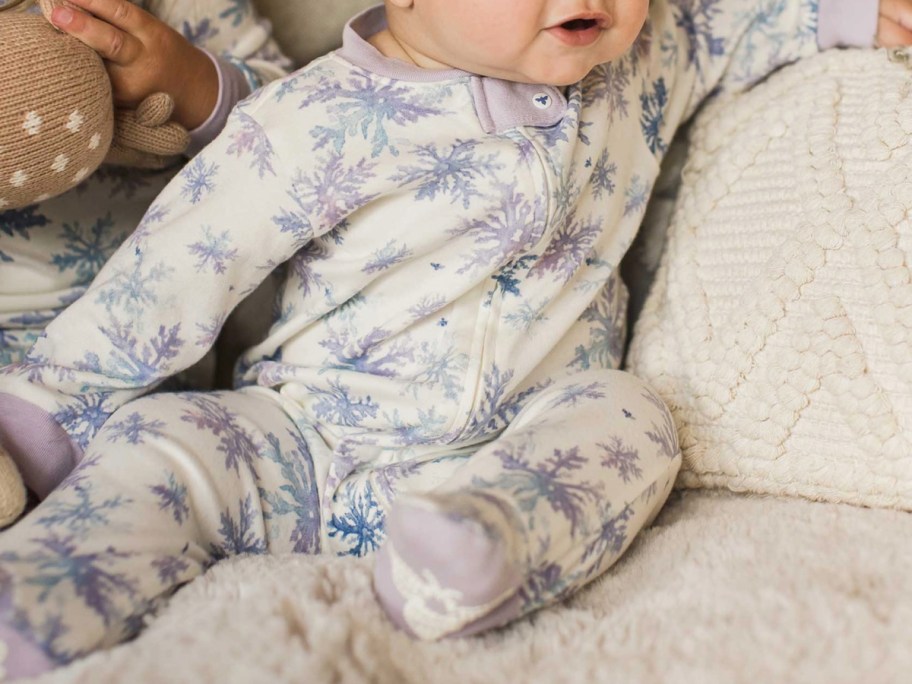 baby sitting in snowflake jammies