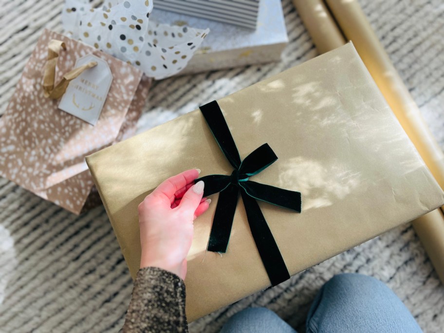 hand holding velvet green ribbon on box