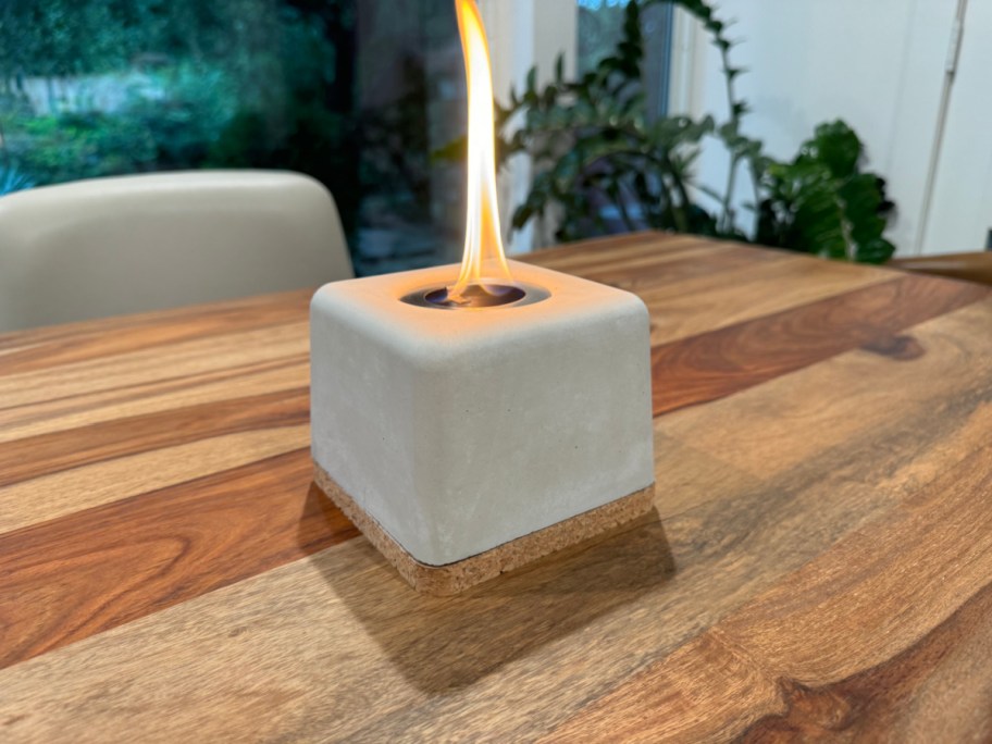 burning concrete tabletop firepit sitting on a wooden surface