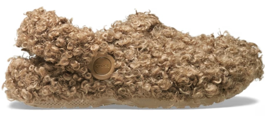 a Crocs clog with light brown faux golden doodle like fur on the outside and inside