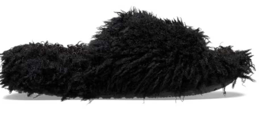 a Crocs slide with black faux dog like fur on the outside and inside