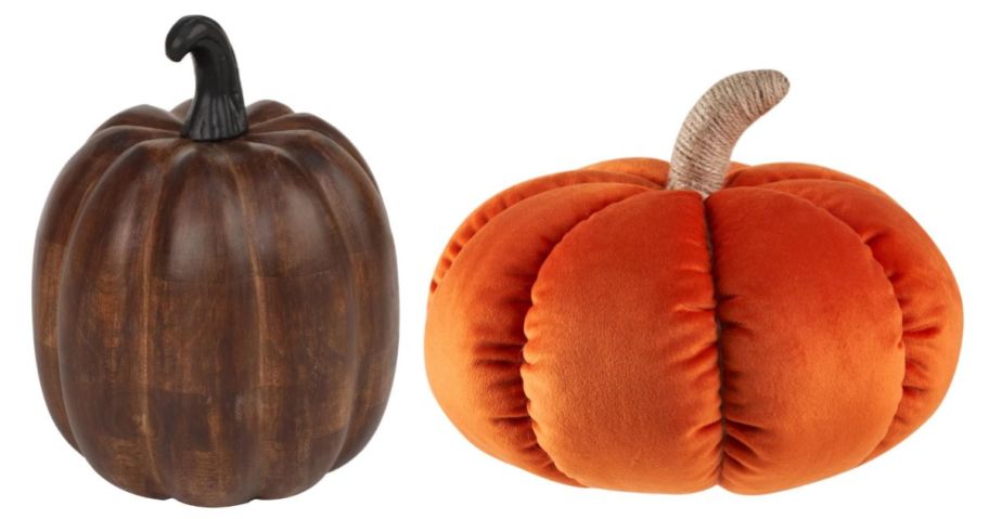 a wooden brown pumpkin and an orange pumpkin pillow