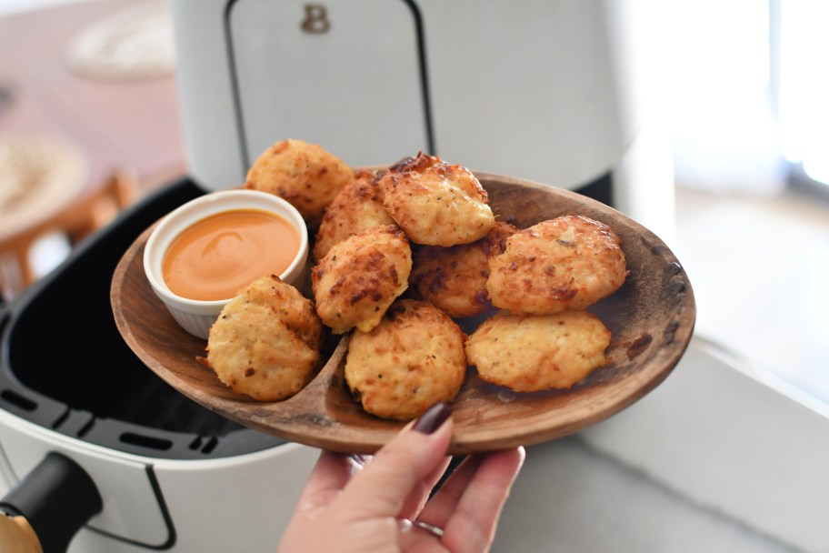 holding air fryer chicken nuggets with dipping sauce