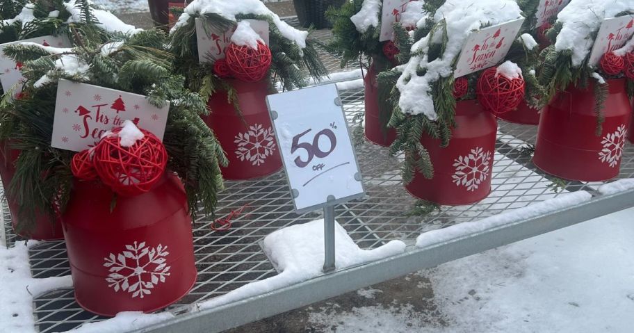 home depot holiday greenery on display outside with 50% off sign in front of it