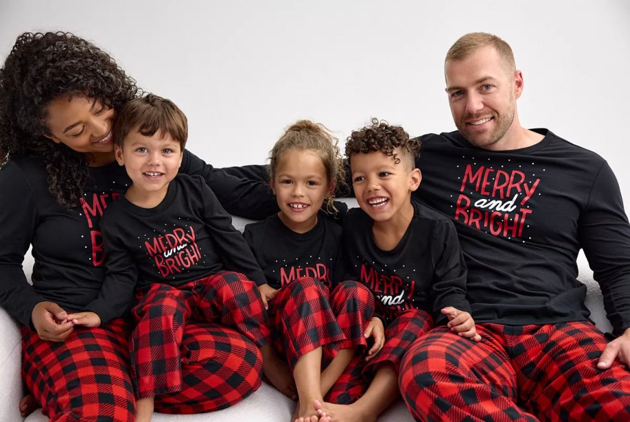 family wearing black and red Christmas pajamas