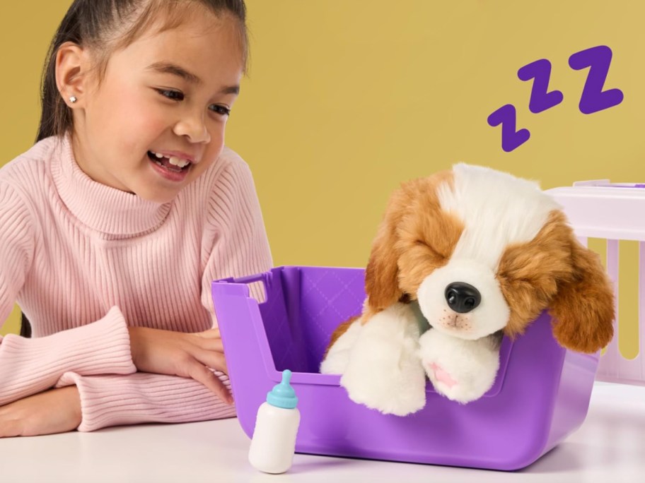 girl looking at puppy sleeping in carrier