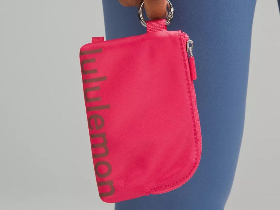 person holding red lululemon pouch