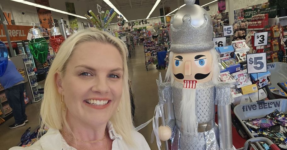 woman taking selfie with nutcracker in store