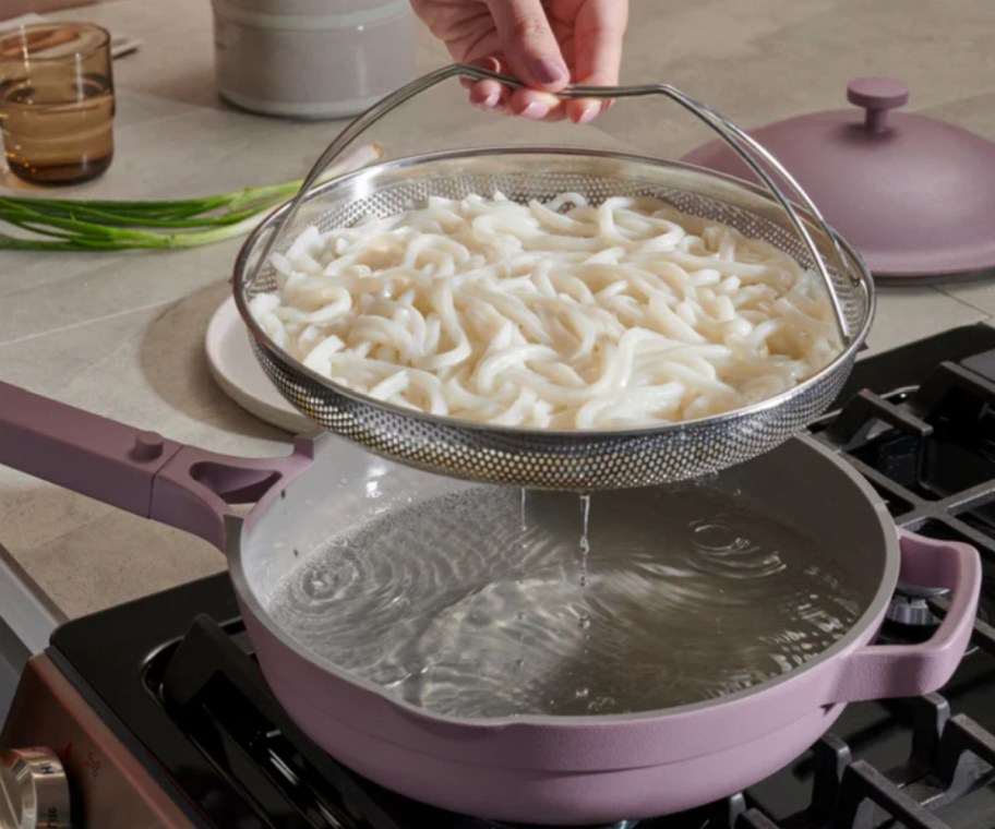 hand grabbing steamer basket out of purple always pan