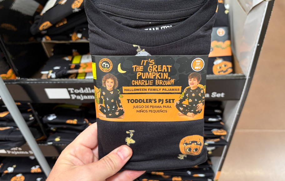 hand holding black toddler pumpkin pajamas 