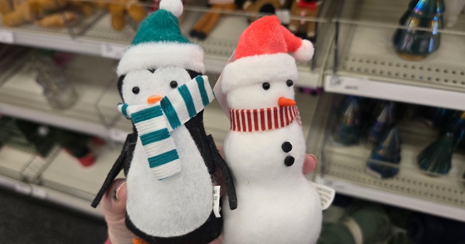 hand holding penguin and snowman plush