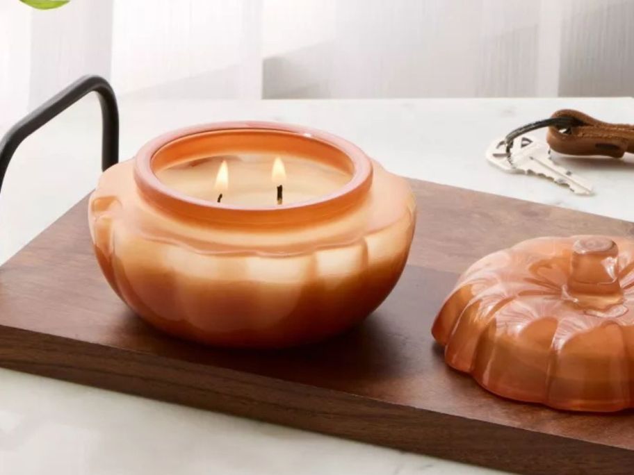 Threshold Lidded Glass Pumpkin Jar Candle lit on table