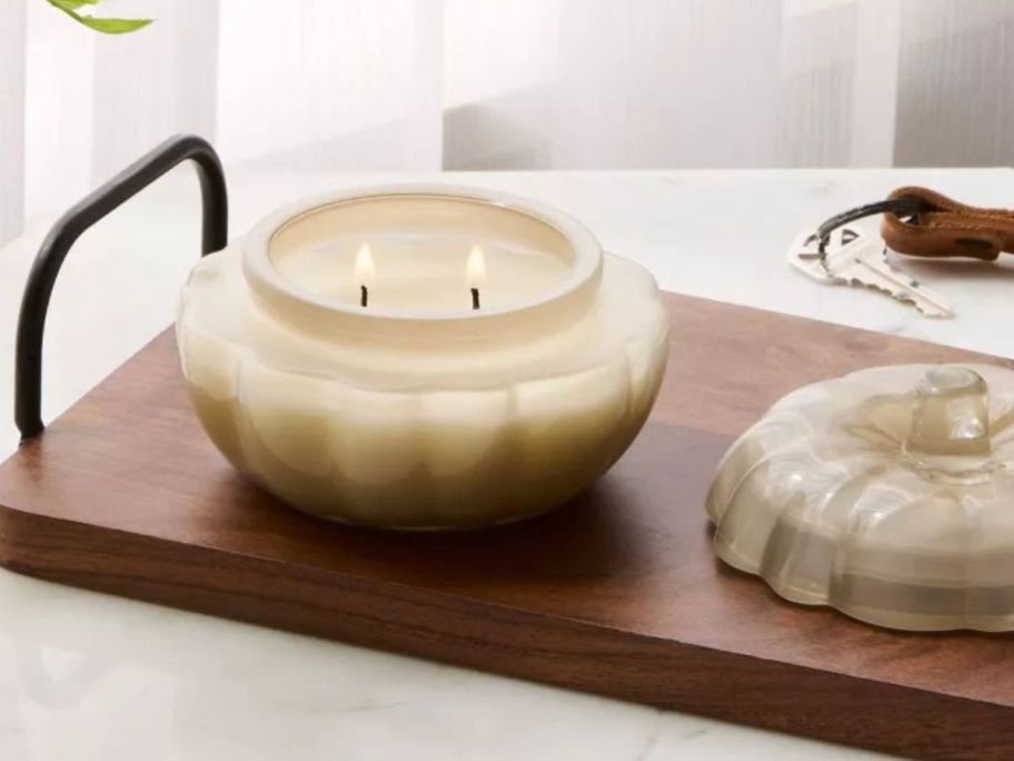 Threshold Lidded Glass Pumpkin Jar Candle lit on table