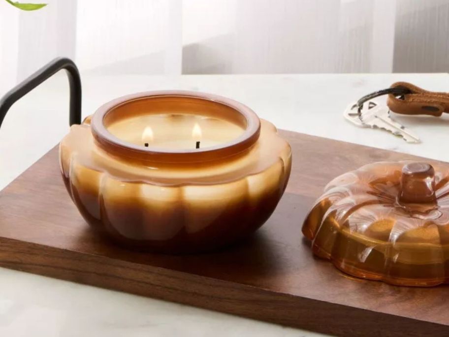 Threshold Lidded Glass Pumpkin Jar Candle lit on table