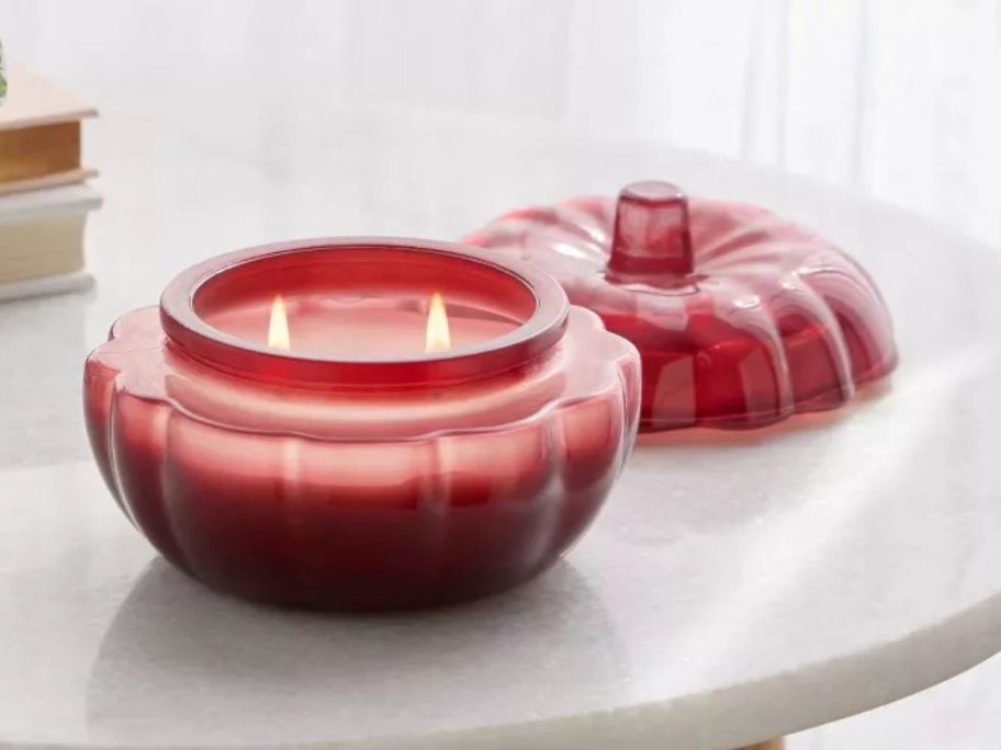 Threshold Lidded Glass Pumpkin Jar Candle lit on table