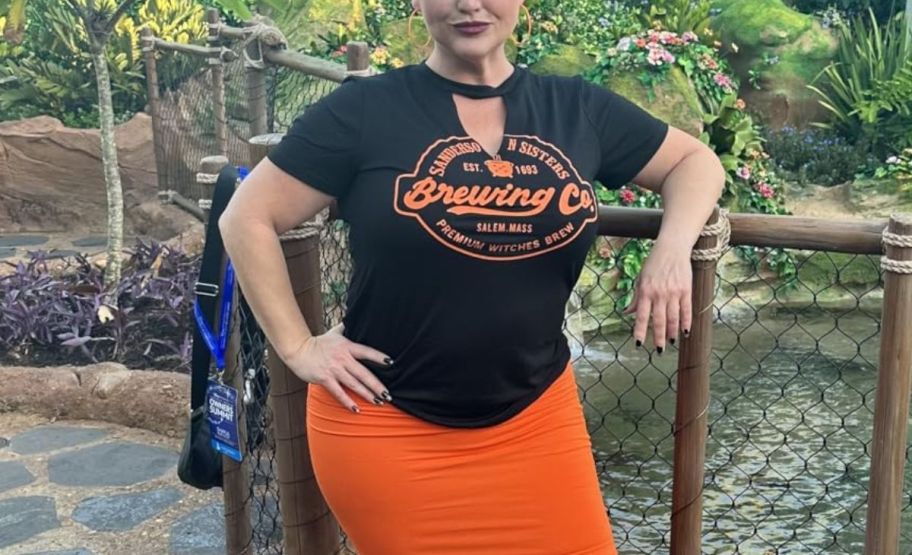 a woman in a black hocus pocus tee and an orange skirt