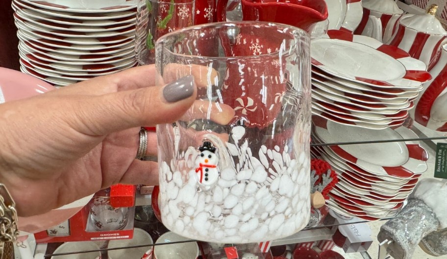 womans hand holding a snowman icon glass 