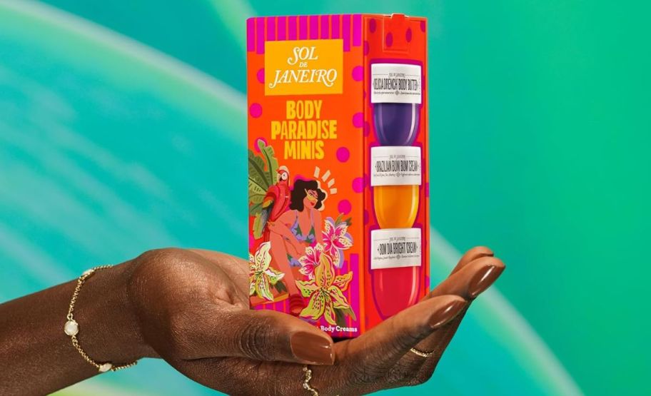 a womans hand holding a 3 pack box of body paradise mini lotions