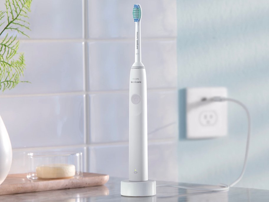 white sonic care toothbrush on charger on counter