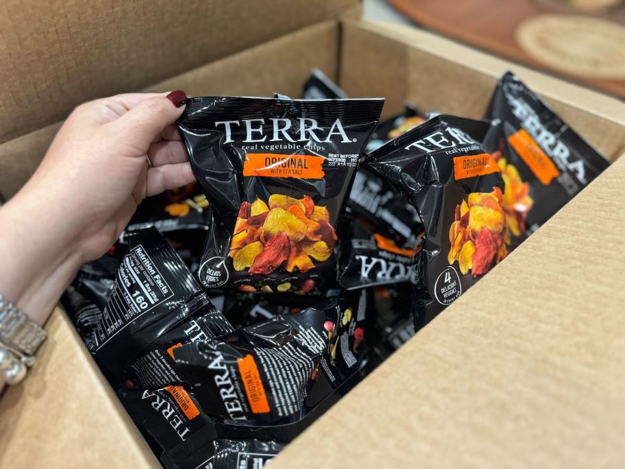 hand holding bag of terra chips from box