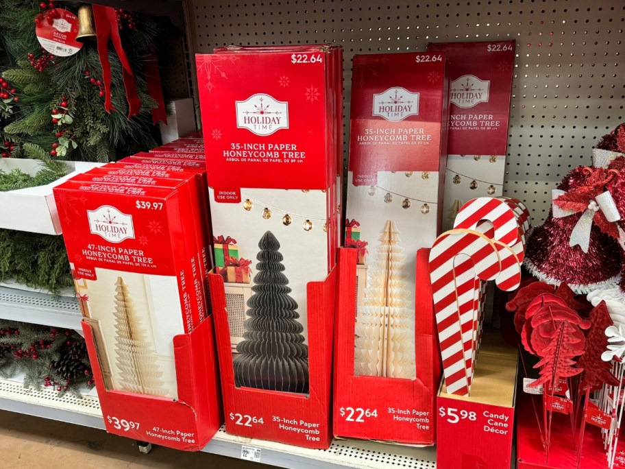 boxes of paper Christmas trees and other Christmas decor on a shelf at Walmart