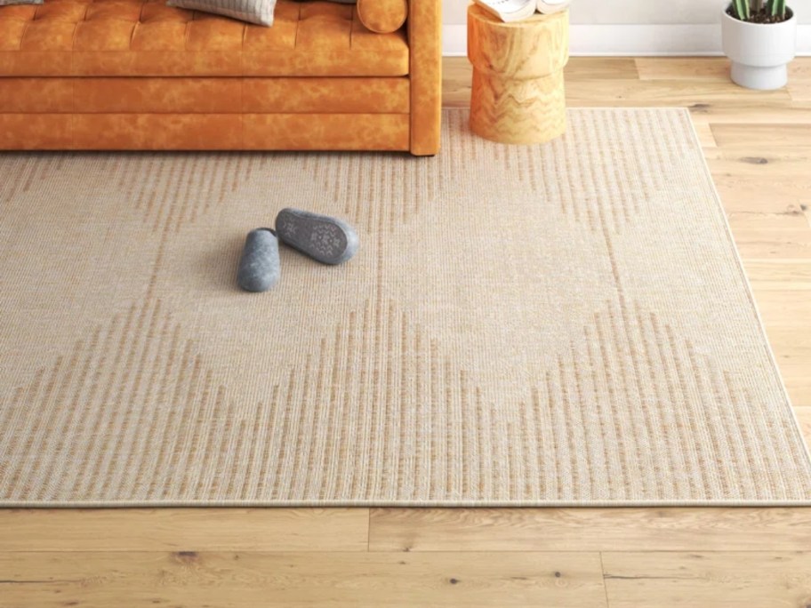 a tan geometric area rug in a living room