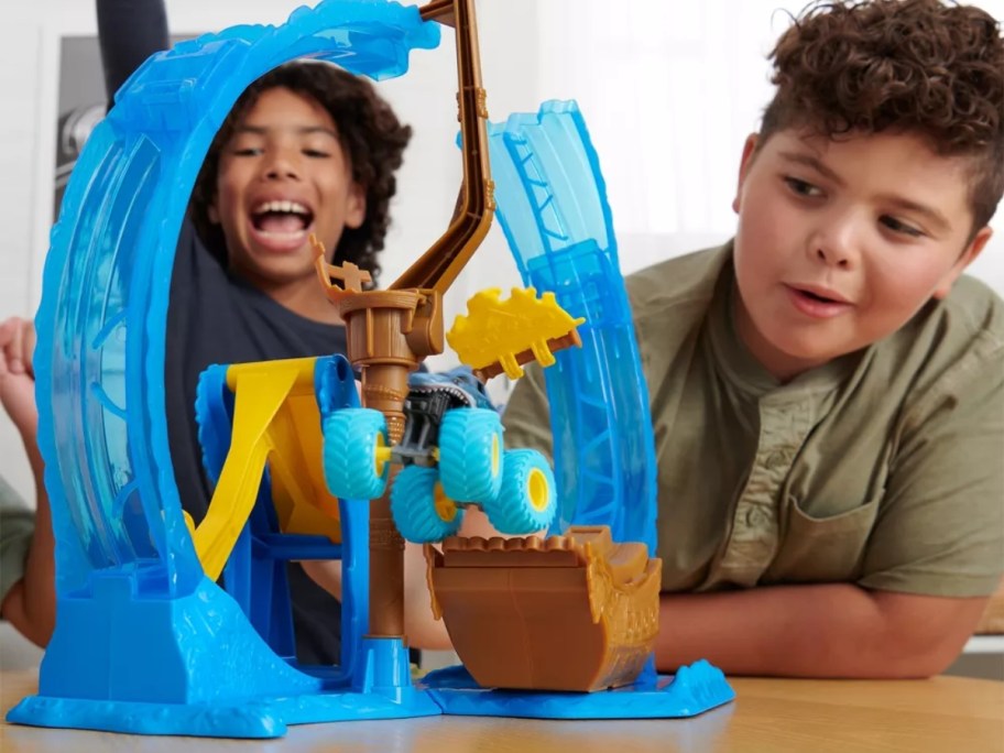 boys playing with a Monster Jam loop playset and cars