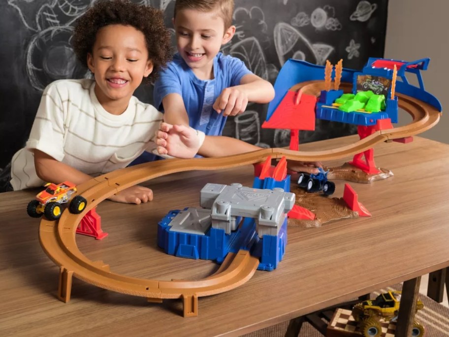 kids playing with a large toy car speedway playset and toy cars