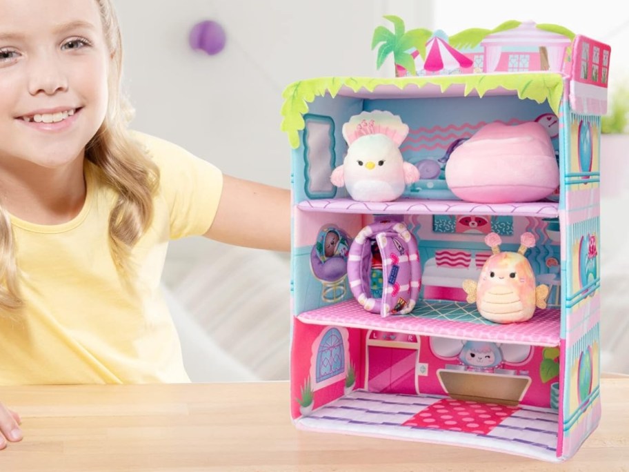 little girl playing with Squishmallows toy inn with mini Squishmallow toys 