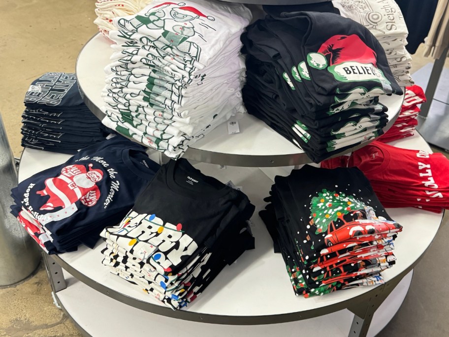 a round tiered clothing display with holiday Christmas graphic tshirts for men and women