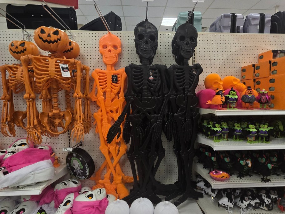 store aisle in Target with Halloween decor orange and black skeletons, skulls, pumpkins and more