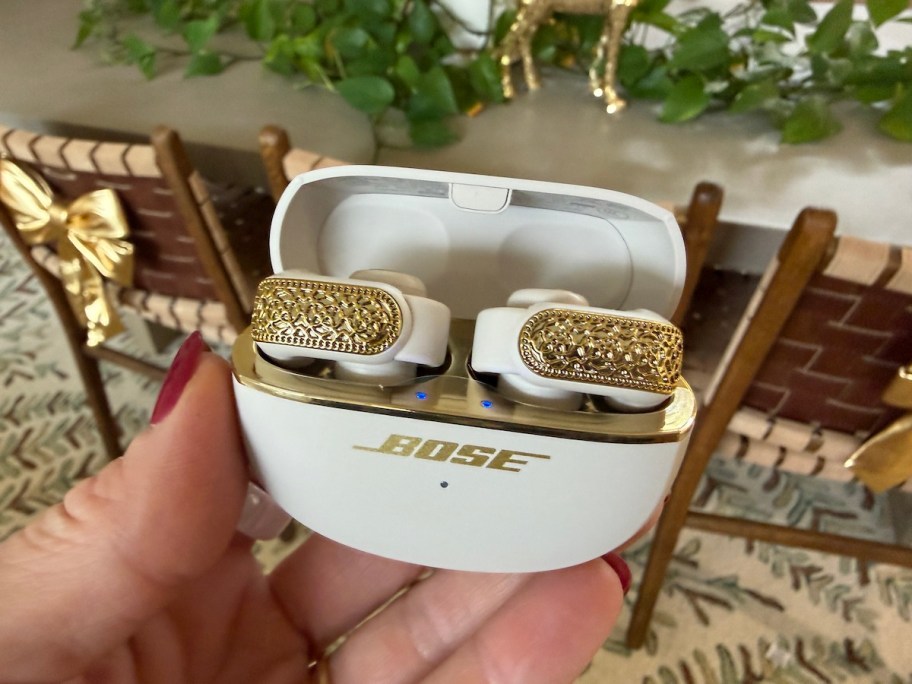 hand holding bose gold headphones