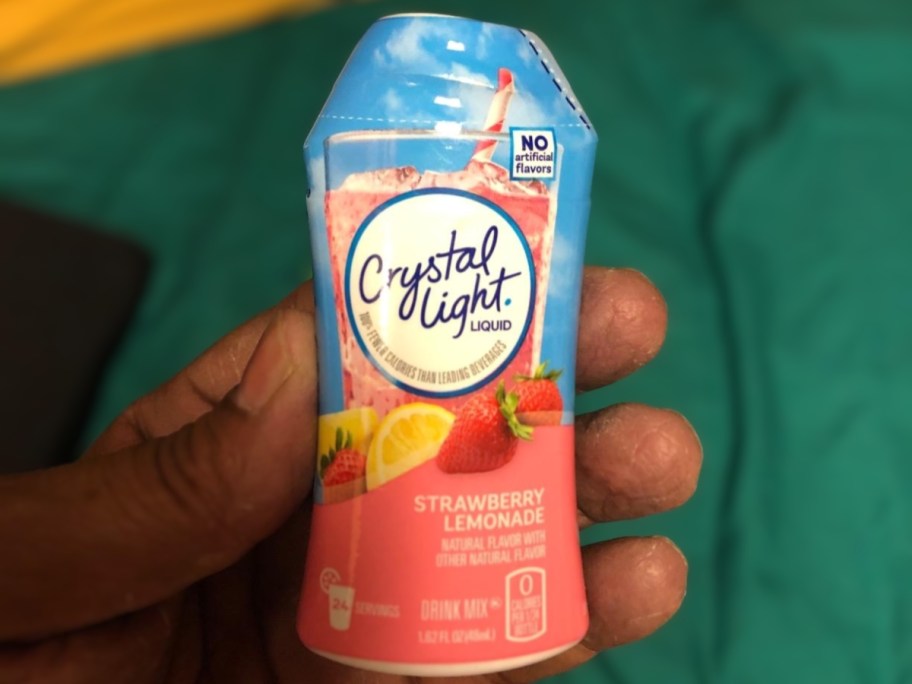 person holding strawberry lemonade crystal light water enhancer bottle