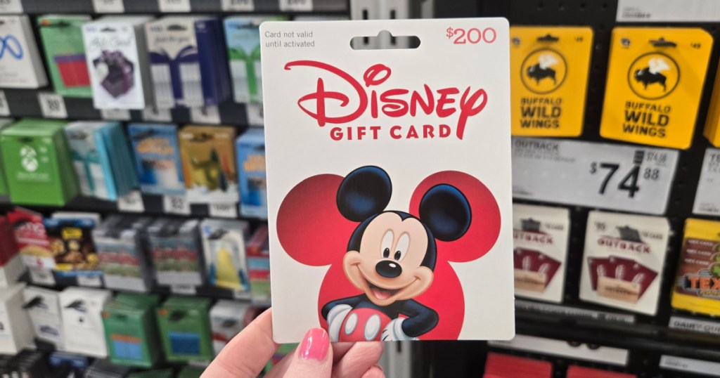 person holding $200 Disney gift card in sams club