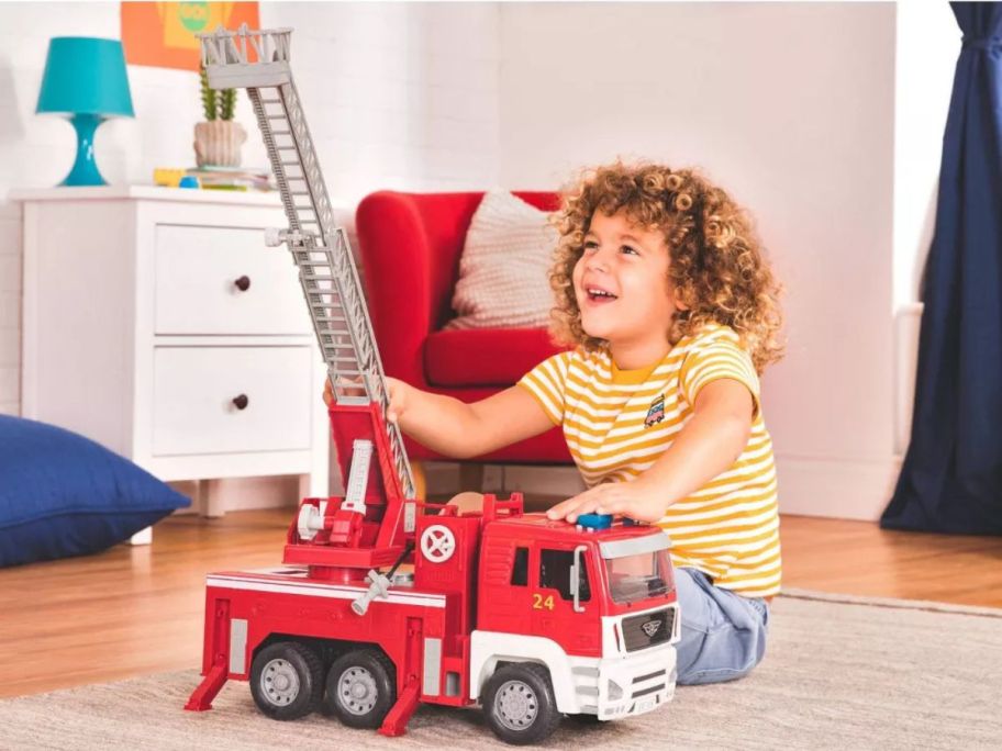 Little boy playing with a Driven by Battat Fire Truck