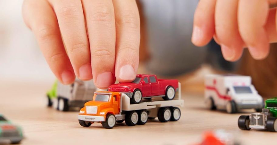 Child playing with little Driven by Battat Trucks