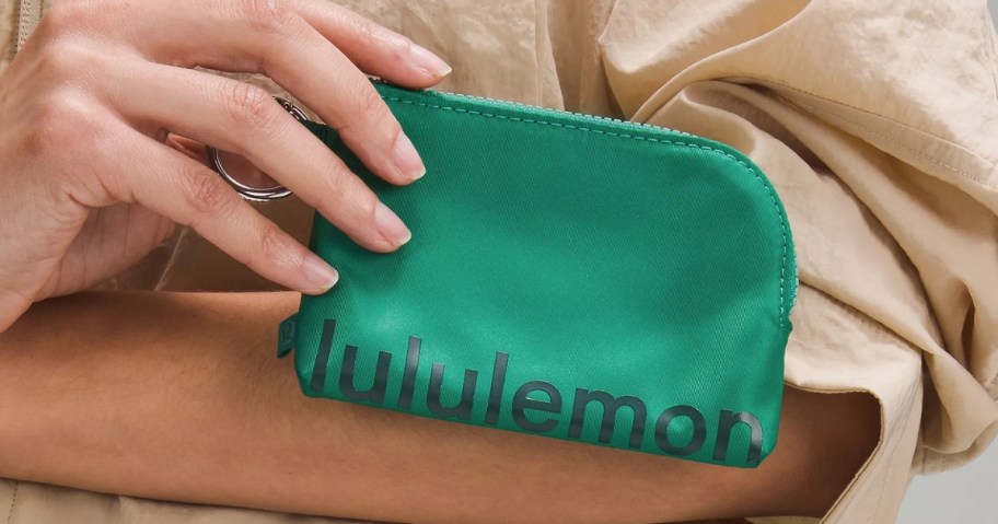 hand holding a green lululemon Clippable Card Pouch