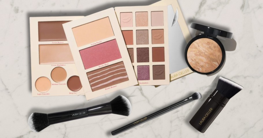 a set of 3 makeup palettes and a mirror, an open face powder and 3 makeup brushes on a marble counter