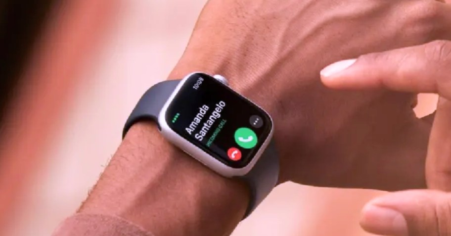 a person's hand and wrist wearing an Apple Watch 