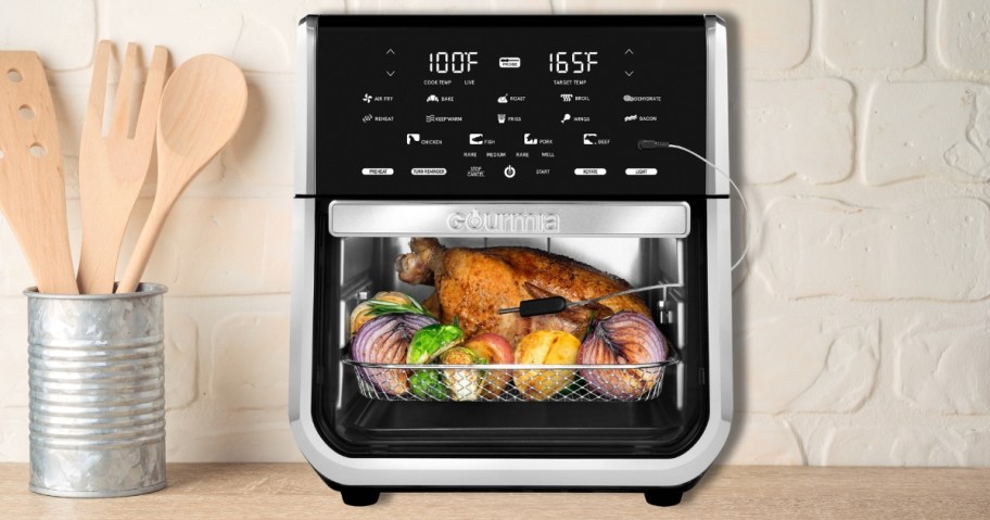 a large black and silver Gourmia All-in-One 14-Quart Air Fryer with food in it on a kitchencounter
