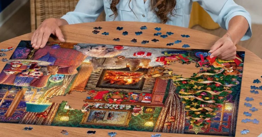 woman putting together a large Christmas puzzle