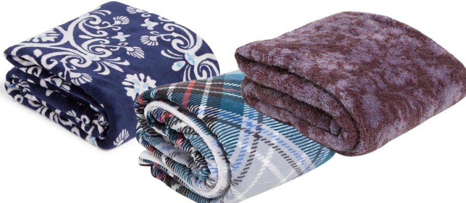 3 Vera Bradley throw blankets folded, one is blue with a medallion print, one with a plaid print and one purple shimmery