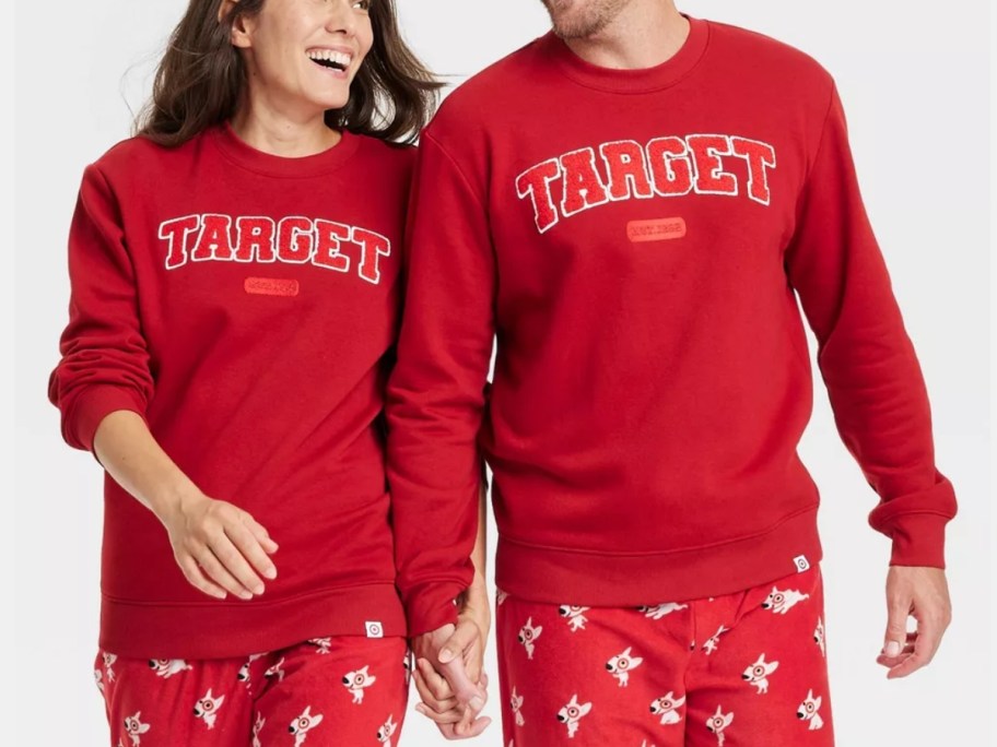 woman and man holding hands wearing matching red color sweatshirts that have 