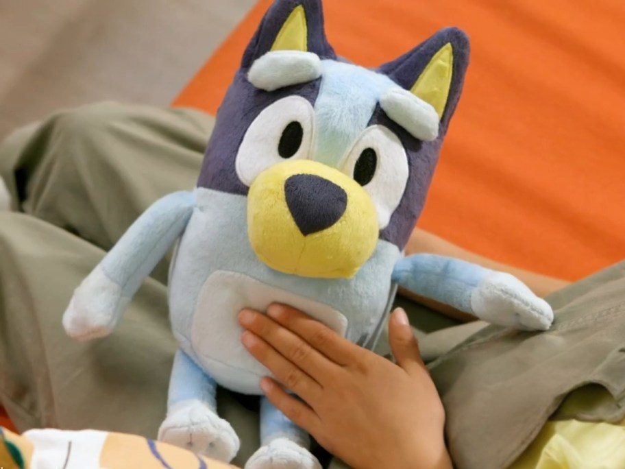 child holding a Bluey 13" Talking Plush animal