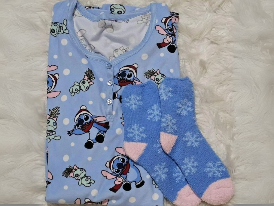 a blue women's nightshirt with Stitch in a Santa hat folded over and a matching pair of plush socks