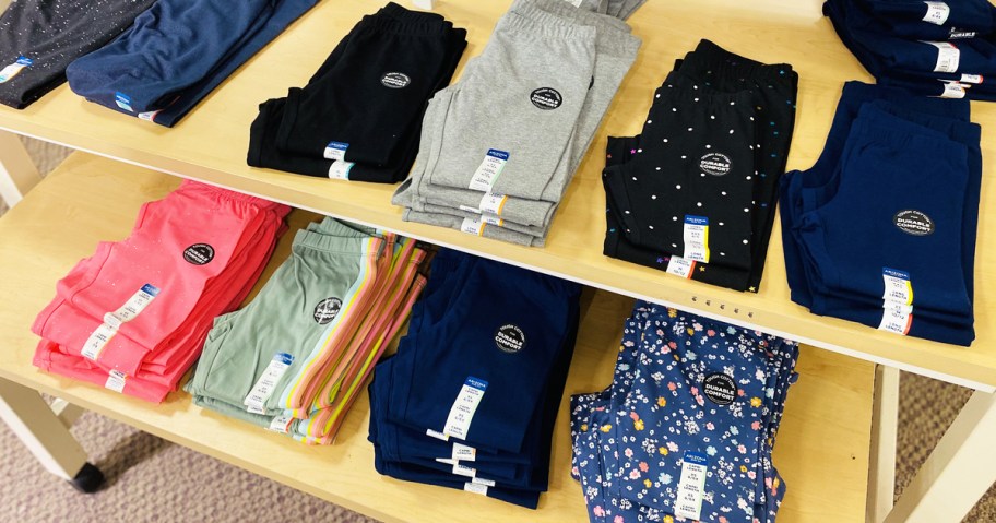 pairs of folded girls leggings on store display table