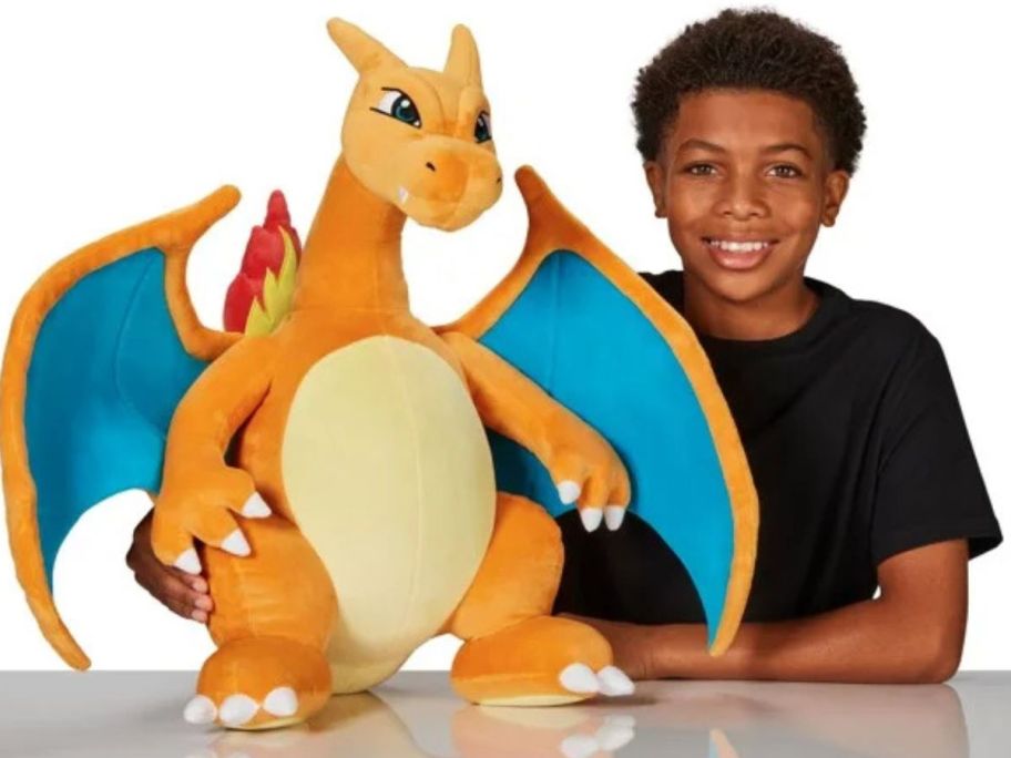 Boy next to a Jumbo Charizard Pokemon Plush